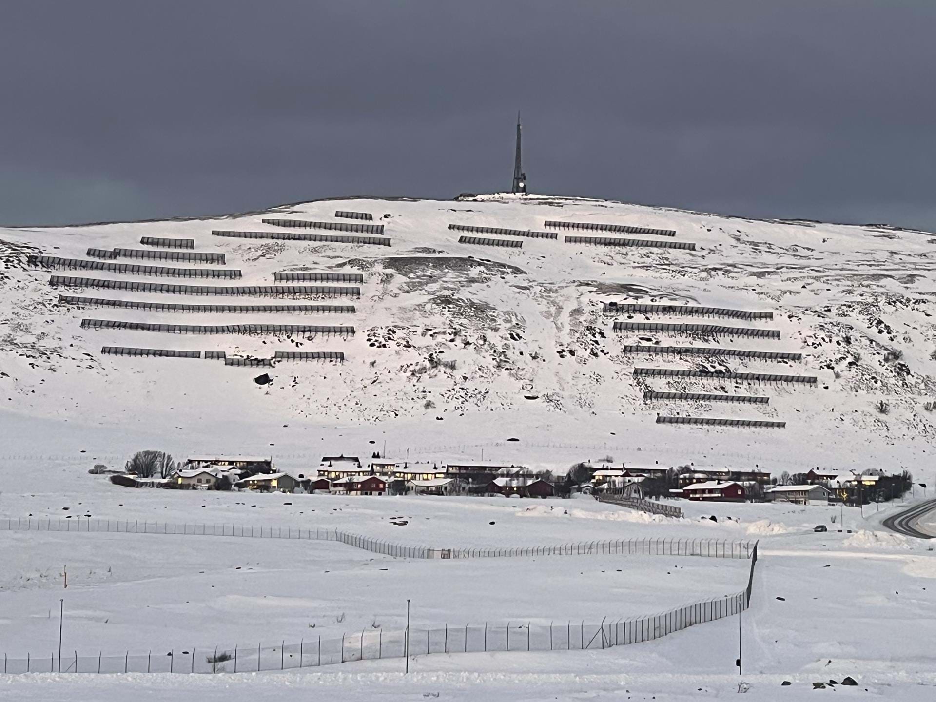 Skredsikring ved Solveien 22 i Hammerfest. Boligene i Solveien lå svært utsatt til for snøskred. 990 meter med stålbroer er satt opp for å hindre at snøskred løsner i fjellsiden bak bebyggelsen. Foto: Espen Salomonsen / NVE